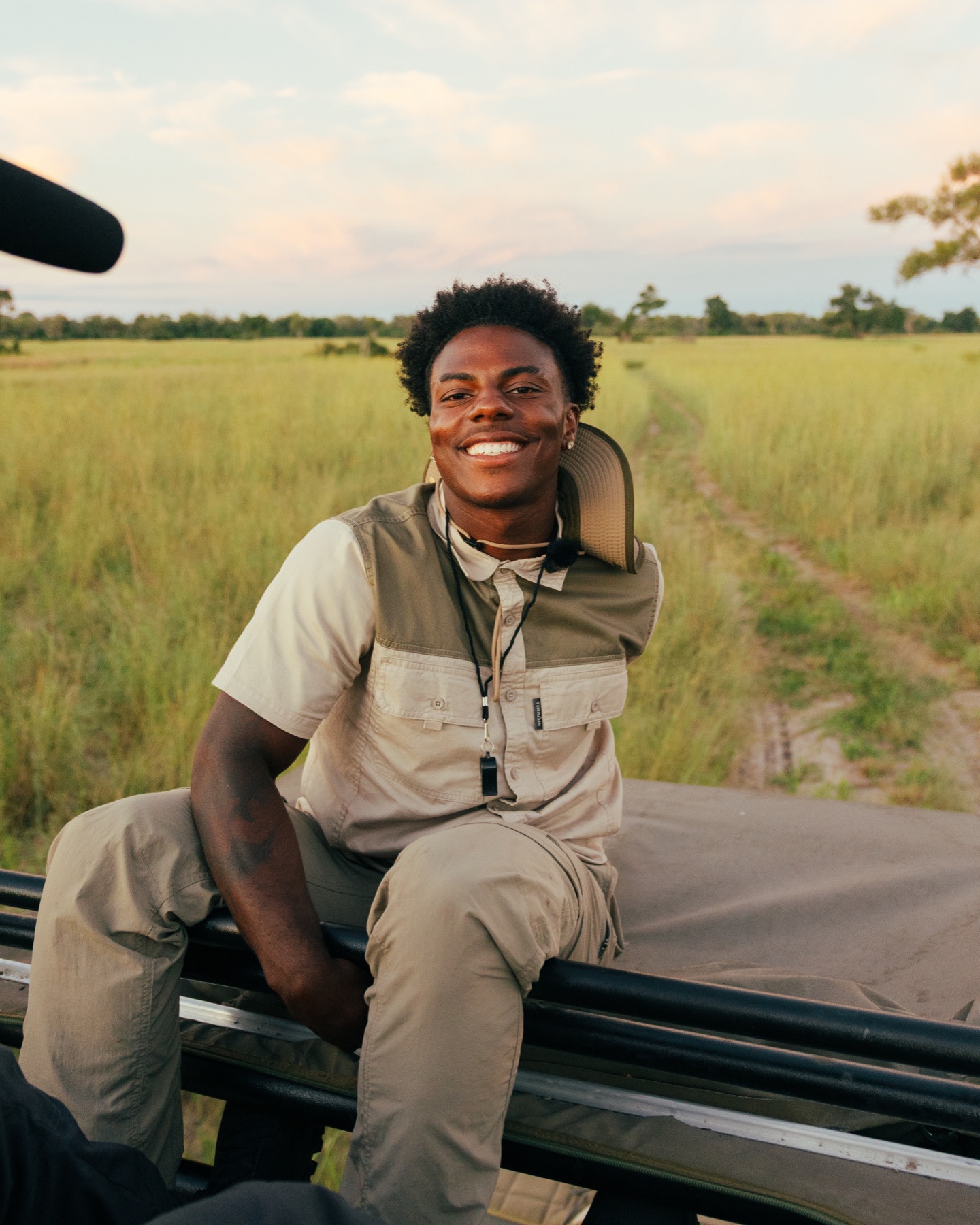IShowSpeed sitting on a safari vehicle in a grass field